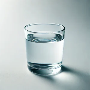 DALL·E 2025 02 11 21.30.32 A simple transparent glass cup filled with clear water placed on a clean white background. The water has a slight reflection of light making it loo